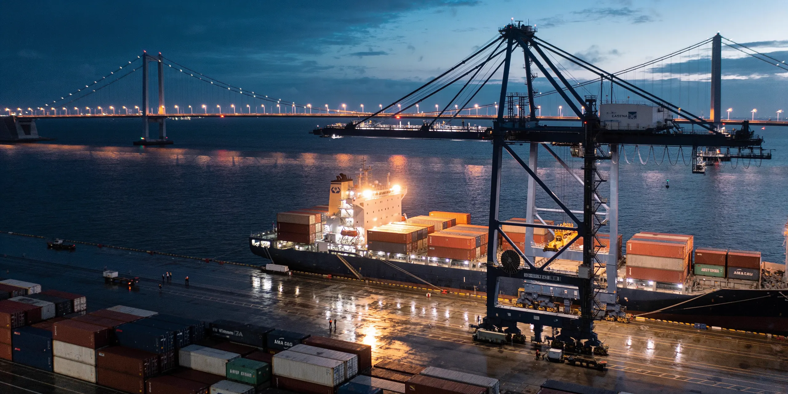 Containerhafen in der Abenddämmerung, Portalkräne beladen ein Frachtschiff